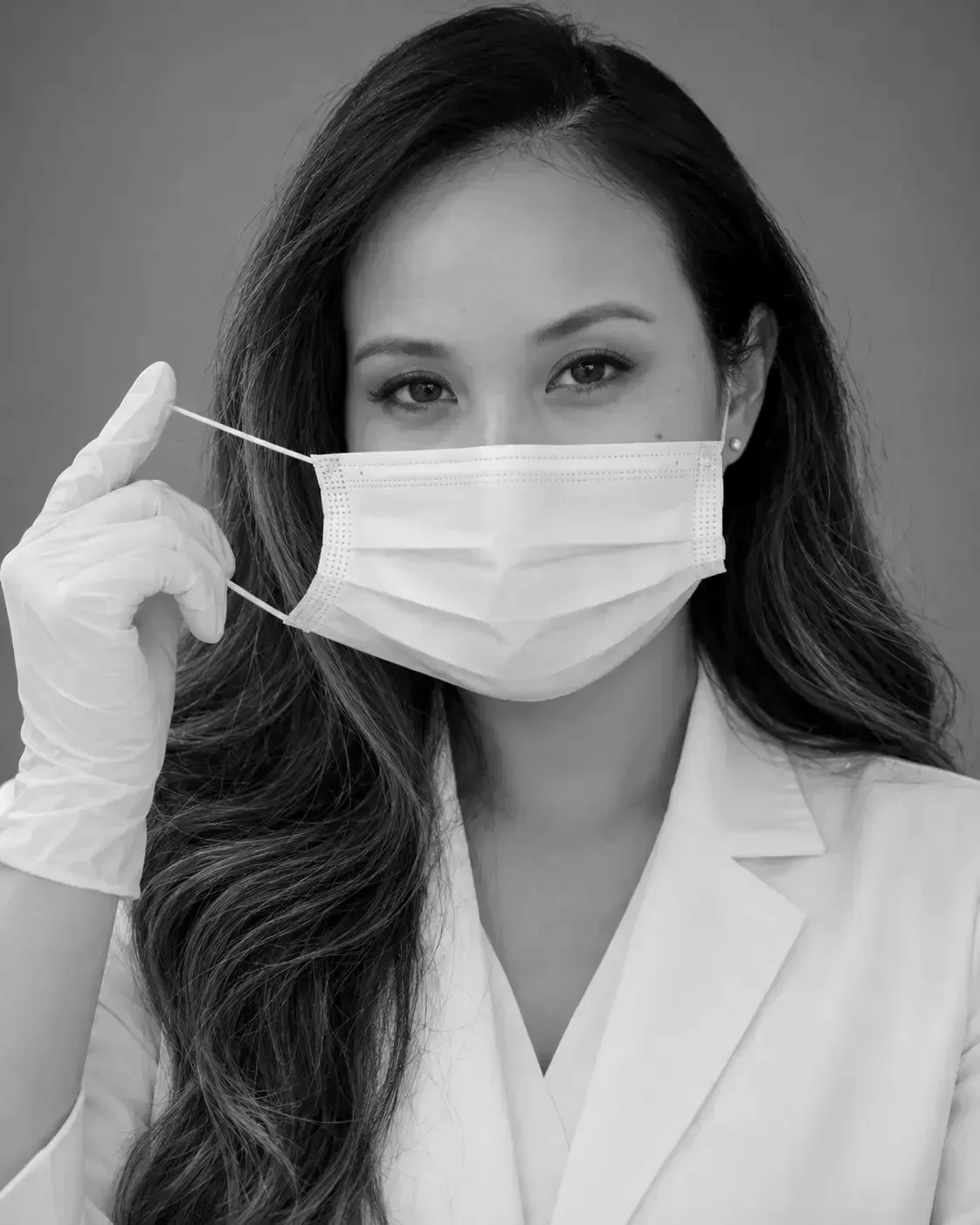 Dr. Mindy Le in a mask and white coat